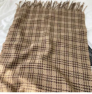 Vue détaillée d'écharpe à carreaux automne hiver, motif classique camel avec franges.