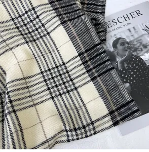 Morbida sciarpa invernale da donna con classico motivo a quadri nero, bianco e beige.