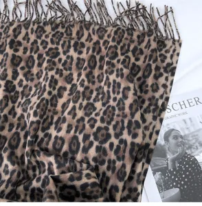 Detailed view of classic leopard print scarf texture, featuring soft fringe and warm autumn fabric.