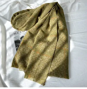Detailed view of cozy olive green plaid fringe scarf, soft cashmere-feel winter accessory.