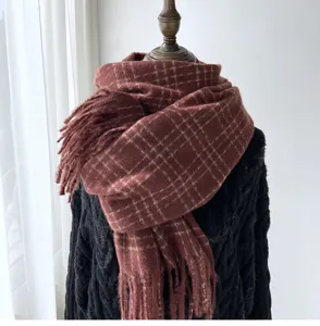Détail rapproché de l'écharpe bordeaux à carreaux douillette avec franges et texture douce.