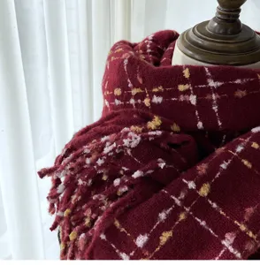 Close-up detail of dark red plaid tassel scarf winter warm knitted wrap cozy style