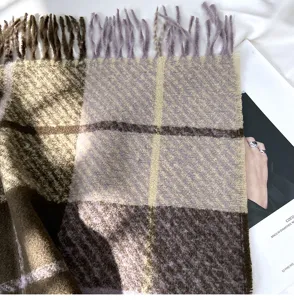 Detailed view of cozy plaid cashmere-feel winter scarf with elegant fringe and check pattern.