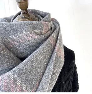 Detailed view of the soft grey plaid winter scarf, cozy imitation cashmere material.