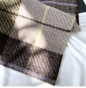 Close-up detail of a thick cozy plaid scarf in purple and brown, soft winter texture.