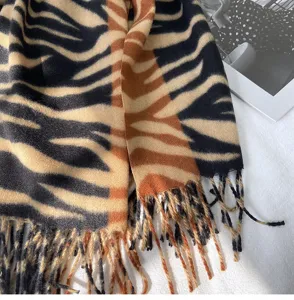 Detail view of autumn winter imitation cashmere scarf with animal print and fringes.