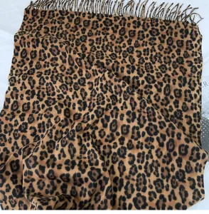 Classic leopard print cashmere-feel scarf detail, showing soft texture and tassel trim.