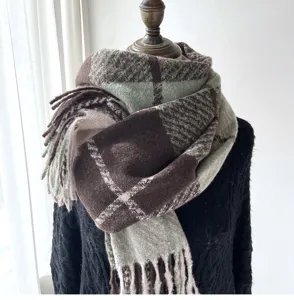 Close-up detail of soft cozy plaid winter scarf with chic fringe and warm cashmere feel.