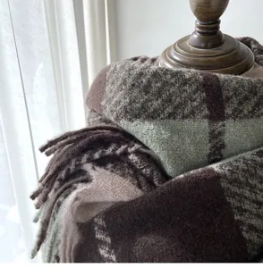 Close-up detail of a cozy green and brown plaid imitation cashmere scarf with chic tassel hem.