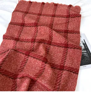 Close-up of cozy red plaid imitation cashmere scarf with stylish tassels for winter warmth.