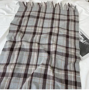 Cozy winter plaid scarf detail showing soft imitation cashmere texture and elegant fringe edges.