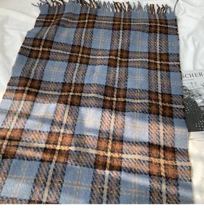Detailed close-up of a blue and brown plaid imitation cashmere scarf with fringes.