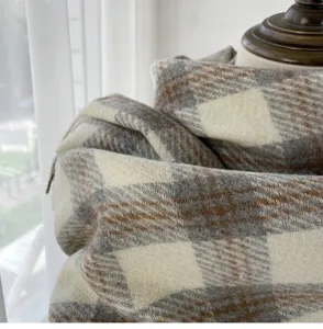 Cozy grey and brown plaid imitation cashmere winter scarf texture close up detail.