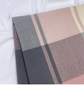 Detailed closeup of a soft autumn winter plaid scarf featuring elegant pink and grey check pattern.