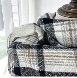 Close-up detail of soft plaid winter scarf fabric, warm cashmere-feel texture shawl wrap.