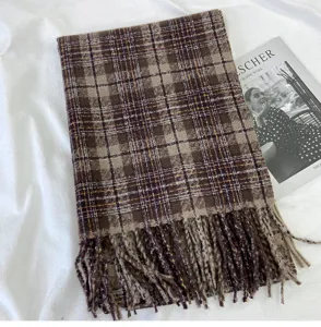 Detail view of a cozy brown plaid fringe scarf, soft winter warm accessory display.