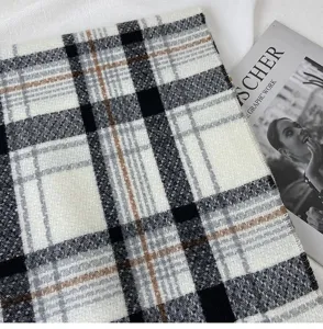 Close-up detail of classic black white and brown plaid cashmere-feel winter warm scarf fabric.