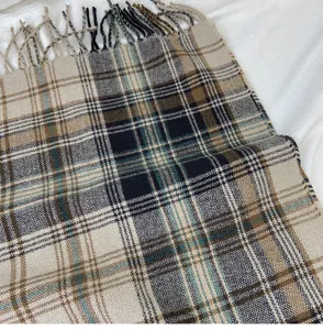 Close-up of retro plaid winter scarf fabric, showing soft cozy texture and elegant fringe details.