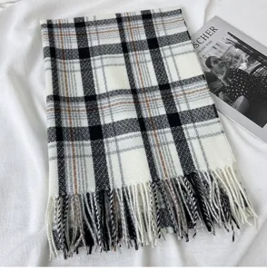 Detailed close-up view of the classic black white and brown plaid winter scarf with cozy fringe.