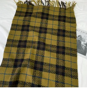 Detailed view of the autumn winter mustard yellow plaid scarf with fringe tassels detail.