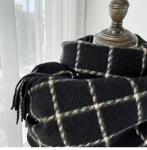 Black and white plaid scarf detail close-up, cozy winter cashmere feel shawl texture.