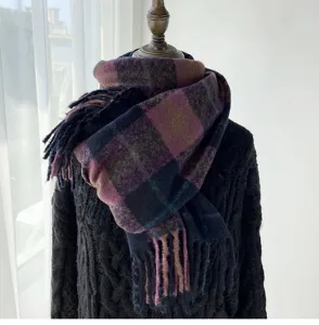 Detail shot of a thick cozy plaid winter scarf with fringe, draped neatly on a mannequin.
