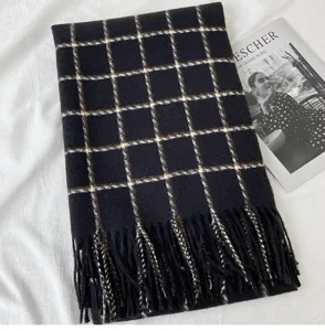 Detail view of a cozy black plaid cashmere-feel scarf with fringe, winter warm chic wrap.
