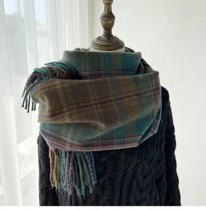 Close-up detail of a retro plaid winter scarf with fringe hems and cozy fabric texture.