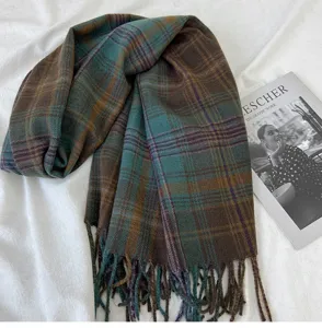 Detail view of retro plaid winter scarf with cozy fringe texture and warm autumn tones.