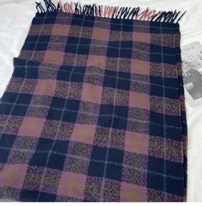 Detailed shot of the thick autumn winter plaid scarf featuring elegant fringes and warm retro tones.