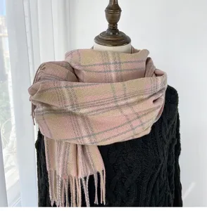 Detail shot of cozy pink plaid winter scarf with fringe, soft warm cashmere-feel fabric