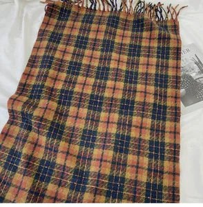 Detailed view of cozy plaid winter scarf with fringe, soft cashmere-feel fabric for daily wear.
