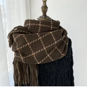 Detailed view of women's thick warm plaid scarf in dark brown with cozy tassel fringe design.