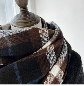 Cozy brown plaid winter scarf detail, soft thick knit material, warm stylish wrap for women.