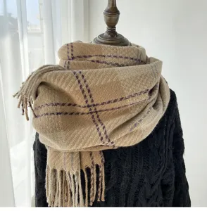 Détail d'écharpe d'hiver à carreaux et franges, écharpe beige épaisse et chaude femme.