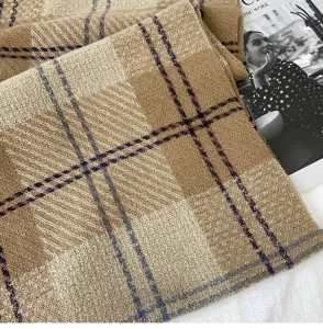 Détail de l'écharpe à carreaux marron chaud, texture de tissu tissé épais pour l'hiver douillet.
