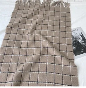 Detailed view of the winter plaid cashmere-feel scarf, cozy texture and classic fringe design.
