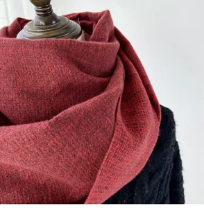 Close-up detail view of a soft dark red winter cashmere-feel scarf draped elegantly.