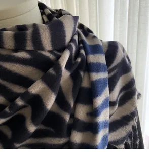 Detail view of women cozy autumn winter imitation cashmere scarf featuring abstract stripe pattern.