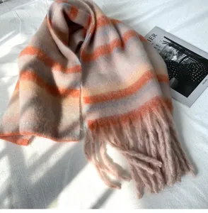 Vue détaillée de la texture douce du foulard rayé en mohair automne-hiver avec franges.