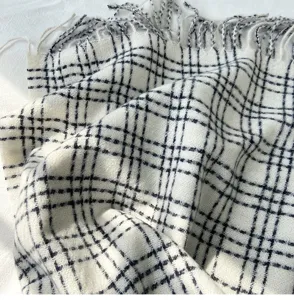 Gros plan détaillé d'une belle écharpe d'hiver à carreaux noir et blanc avec franges.
