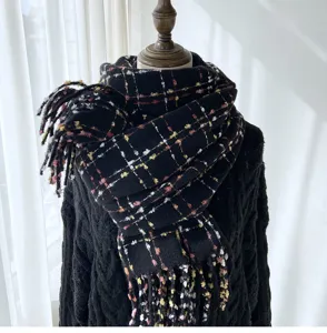 Detailed view of a cozy black plaid winter scarf with fringe, soft warm material, ideal accessory.