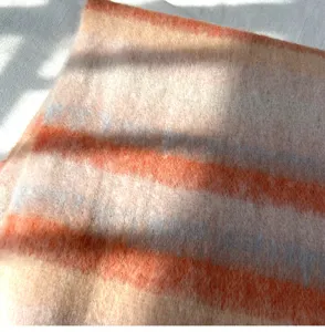 Gros plan du tissu écharpe rayée en mohair doux, montrant les détails de texture.