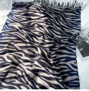 Detailed view of autumn winter imitation cashmere scarf with zebra pattern and fringe design.