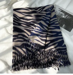 Detail view of a cozy winter zebra print imitation cashmere scarf with stylish fringe edges.
