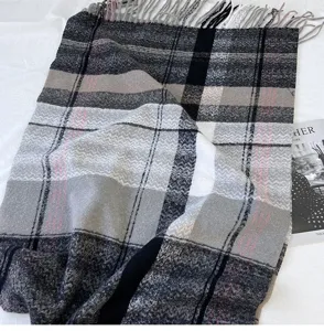 Detailed close-up shot of a black, white and grey plaid tassel scarf for women warmth