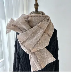 Close-up detail of the cozy winter plaid fringe scarf showing soft texture and pattern.