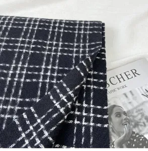 Gros plan sur l'écharpe d'hiver classique à carreaux noirs et blancs, texture douce.