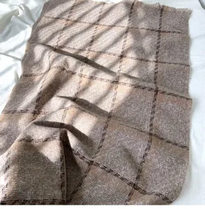 Cozy brown plaid tassel scarf detail, soft imitation cashmere fabric for winter warmth.