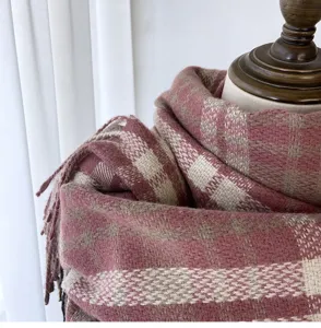 Close-up detail of women winter pink plaid scarf, thick warm cashmere-feel tassel wrap.